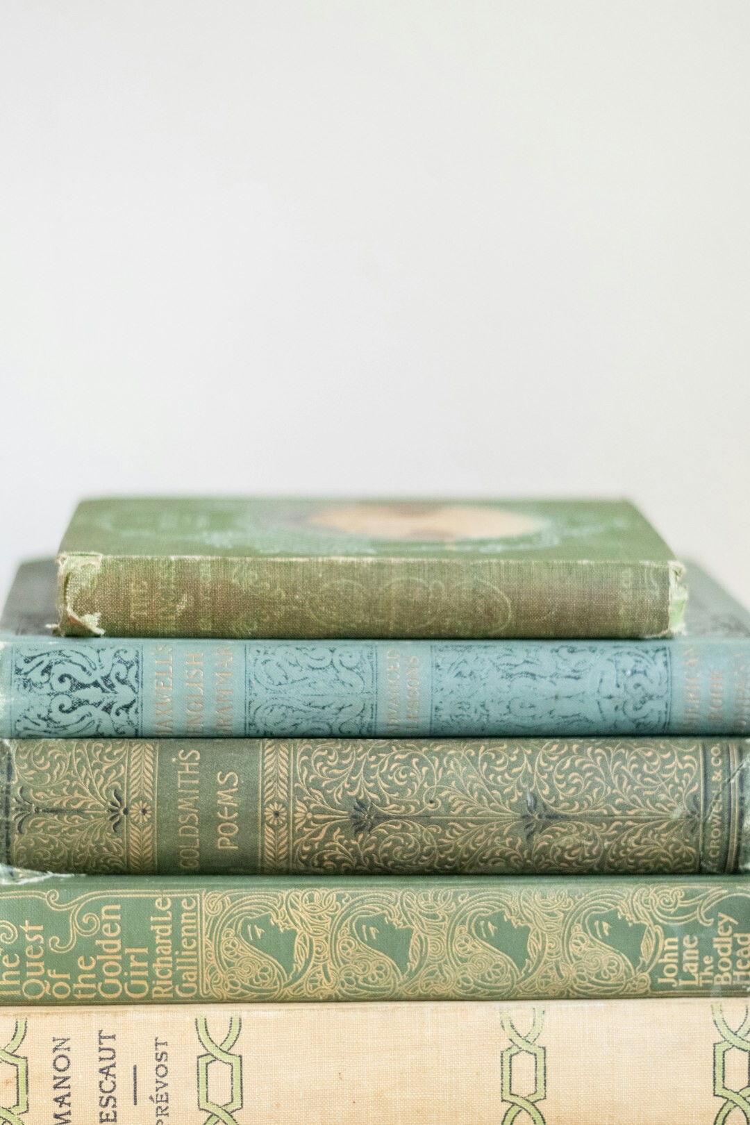 Stack of old worn mystery novels and hardcover books on a wooden table