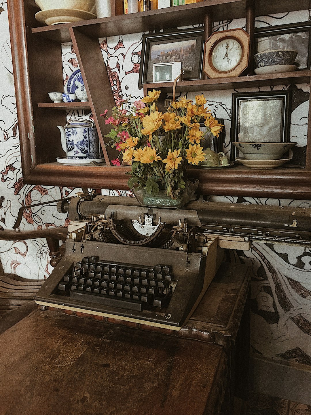 Vintage writer's desk with typewriter, notebooks and a cup of coffee near a foggy window